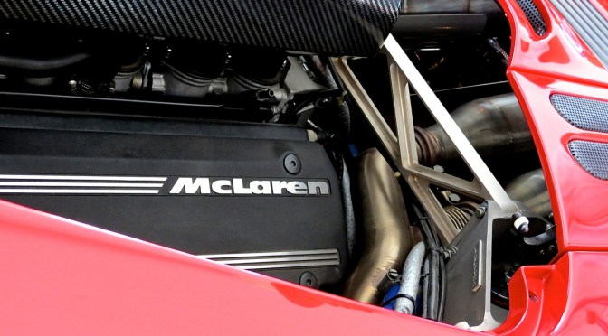 A bright red McLaren F1 in the paddock at Laguna Seca